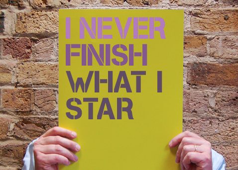 Homme tenant une pancarte sur la procrastination qui dit « je ne finis jamais ce que je star »