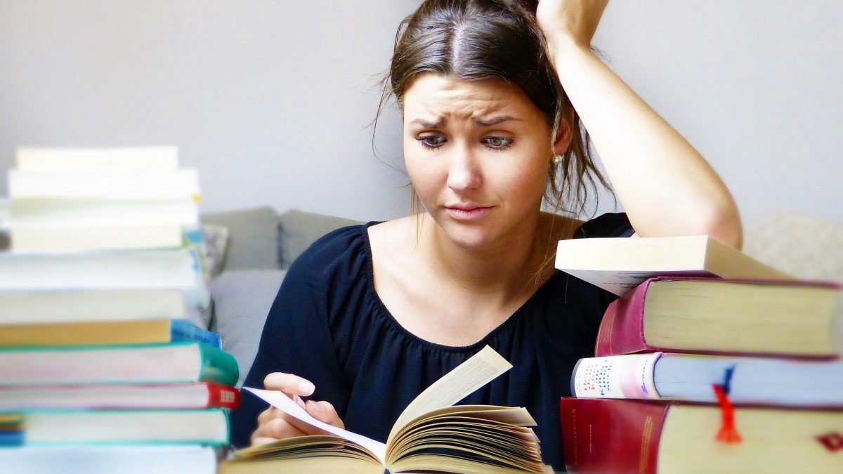 Fille stressée entourée de livres