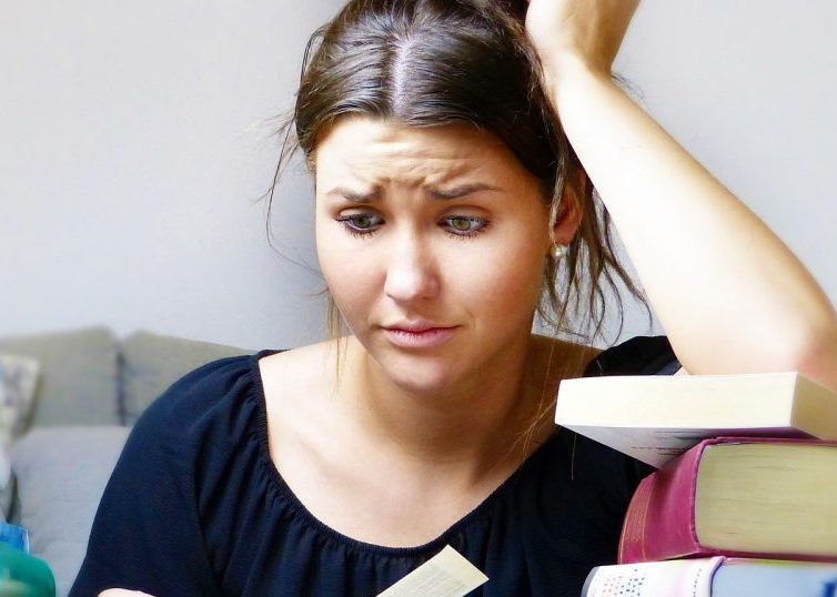 Fille stressée entourée de livres