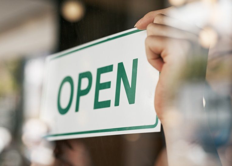 Mains retournant un panneau « ouvert »