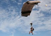 Des gens sur le point d’atterrir sur la plage après avoir fait du parachutisme