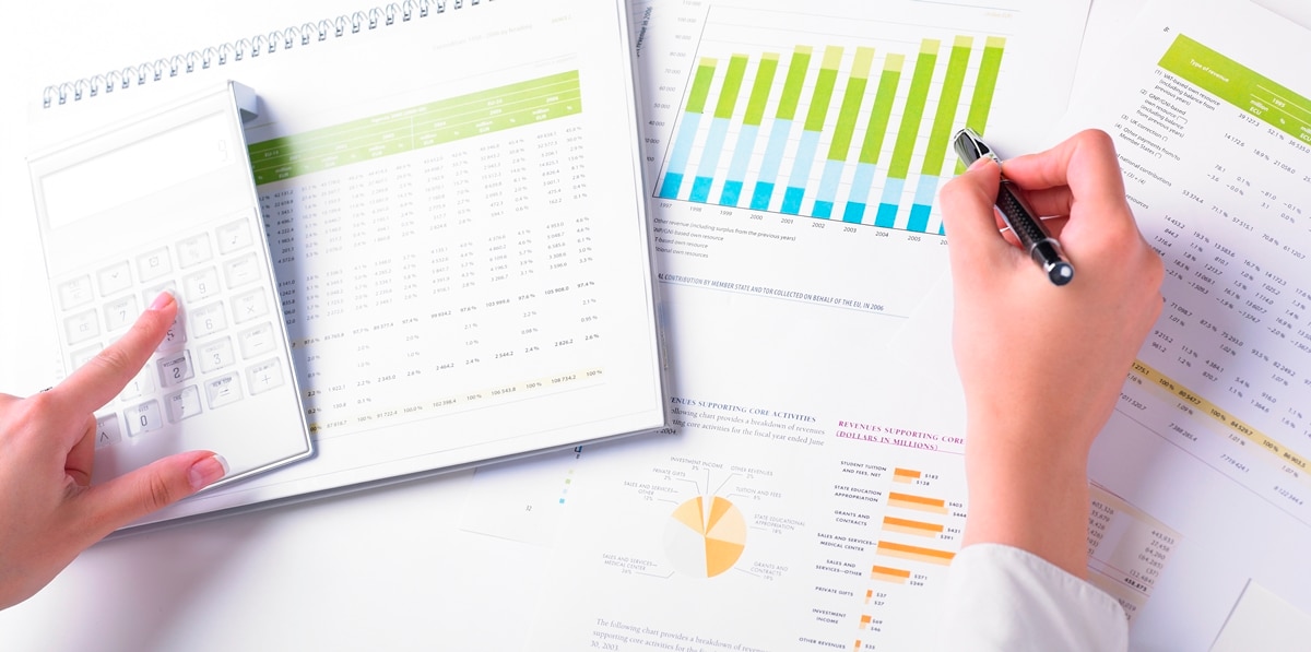 À l'aide de la calculatrice pendant que l'autre main tient un stylo pointant vers un graphique