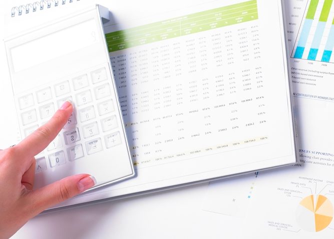 À l'aide de la calculatrice pendant que l'autre main tient un stylo pointant vers un graphique