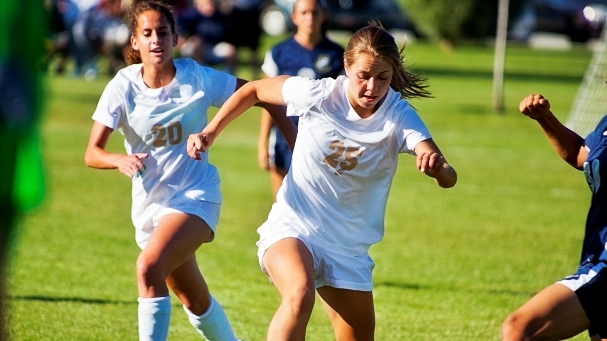 Des filles jouant au football en uniforme blanc