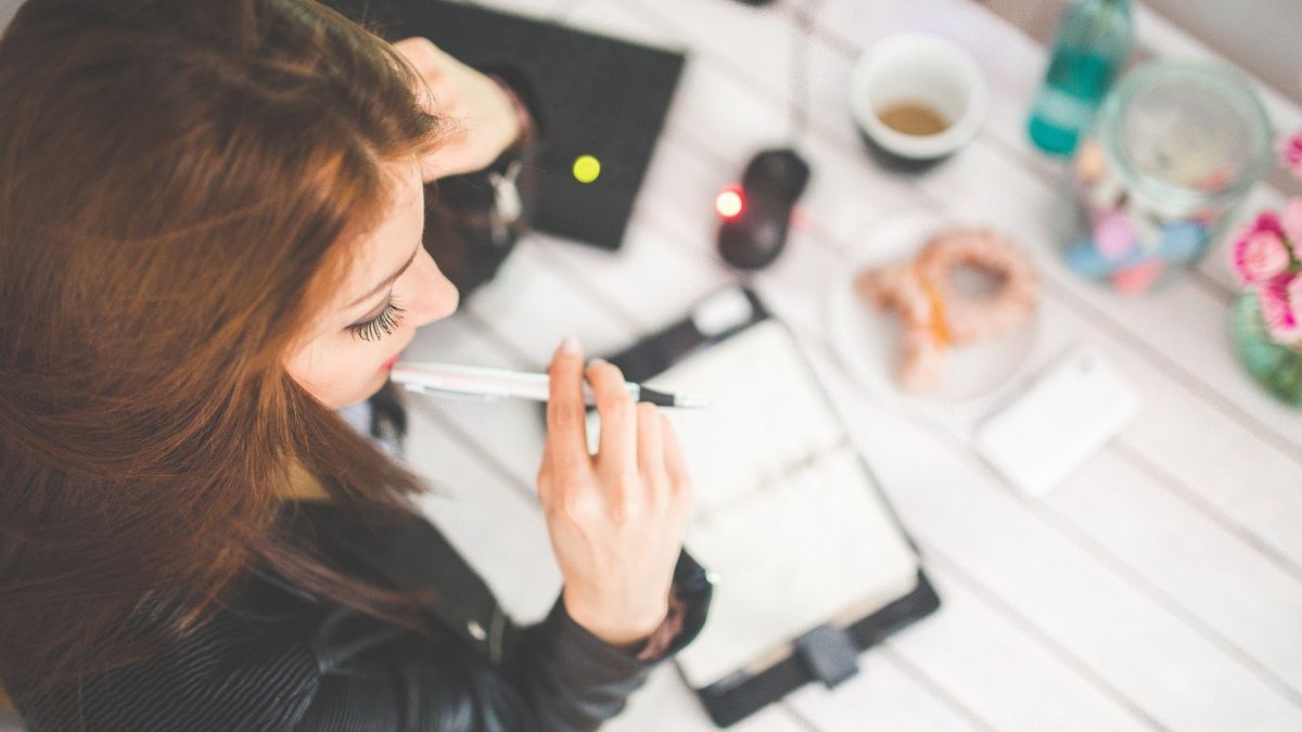 Femme réfléchissant aux choses à son bureau