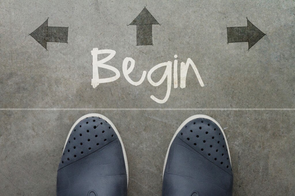 Pieds au sol avec « Begin » écrit entouré de flèches