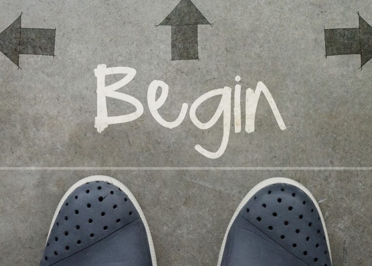 Pieds au sol avec « Begin » écrit entouré de flèches