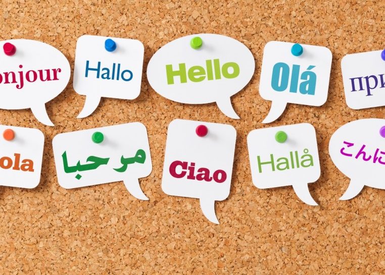 Le mot « Hello » dans différentes langues sur les bulles de mot épinglé sur un panneau de liège