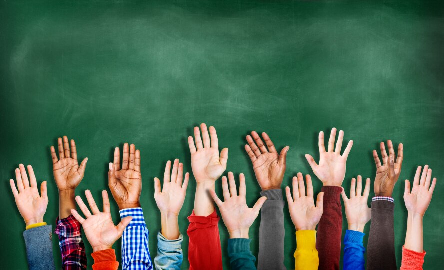 Mains levées devant un fond de tableau de craie