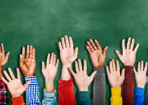 Mains levées devant un fond de tableau de craie