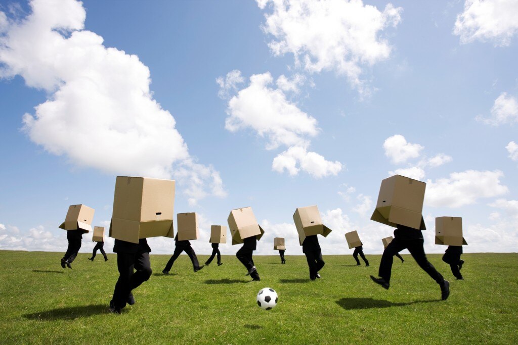 Des gens qui jouent au football avec des boîtes en carton au-dessus de la tête