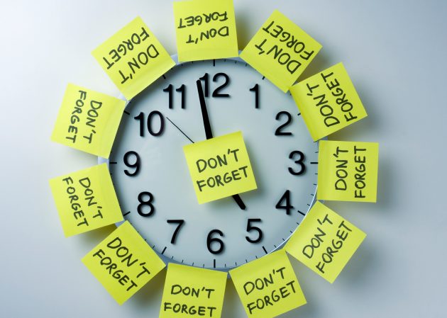 Horloge recouverte de notes adhésives jaunes indiquant « N'oubliez pas »