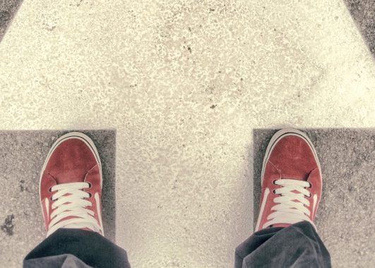 Pieds debout en travers de la flèche peints sur la route