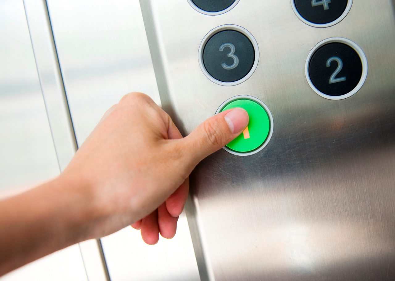 Pression du pouce sur le bouton « 1 » d'un ascenseur