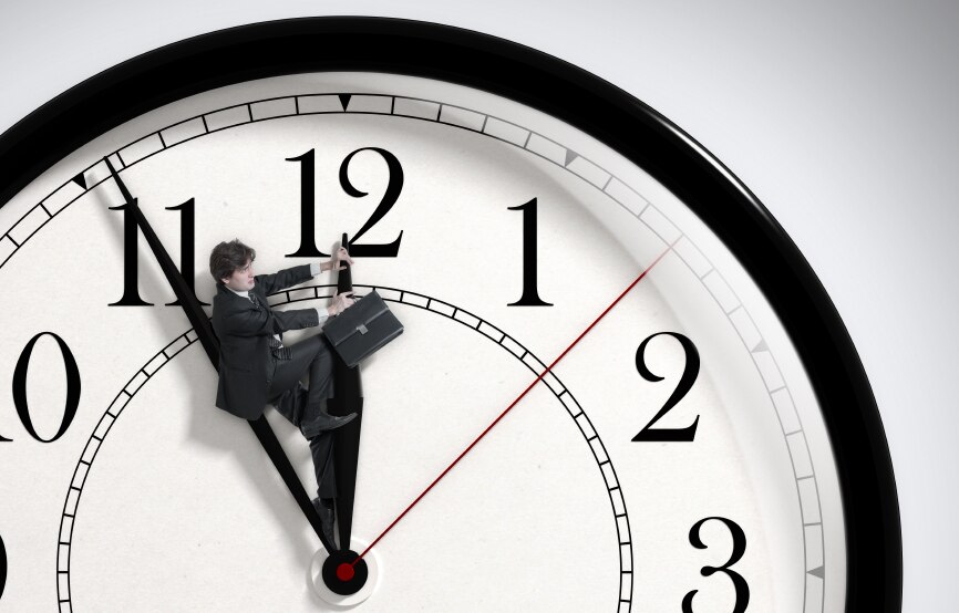 Un homme avec une mallette qui monte sur l'aiguille des heures d'une horloge