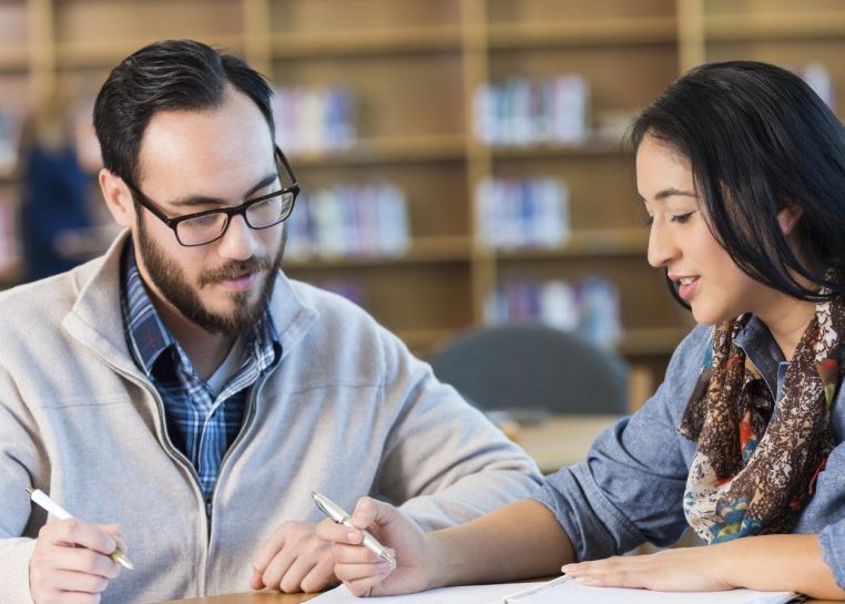 Les étudiants vérifient les notes dans une bibliothèque