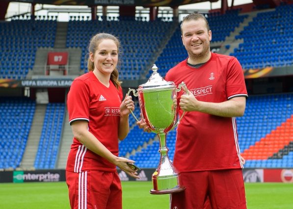 Deux joueurs en uniforme tenant un trophée