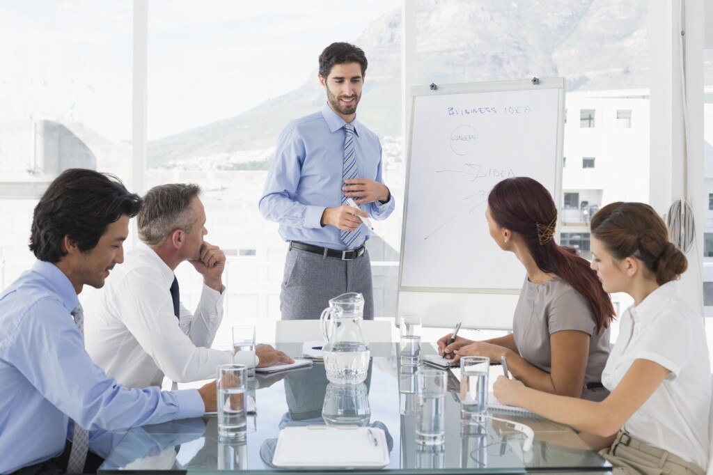 Réunion d’affaires avec le leader écrivant sur le tableau blanc