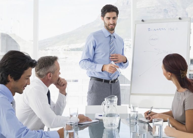 Réunion d’affaires avec le leader écrivant sur le tableau blanc