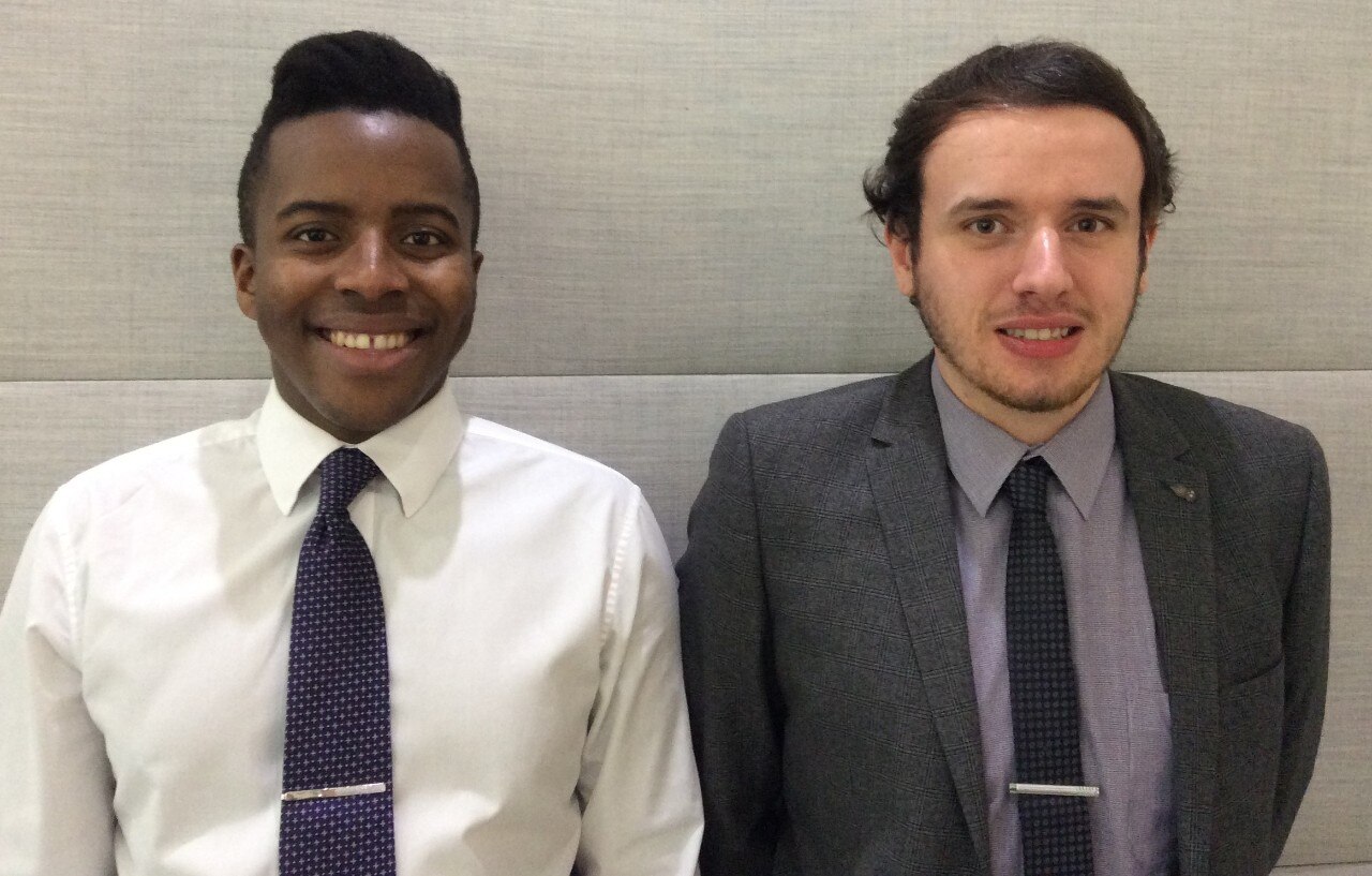 Deux stagiaires habillés formellement et souriants