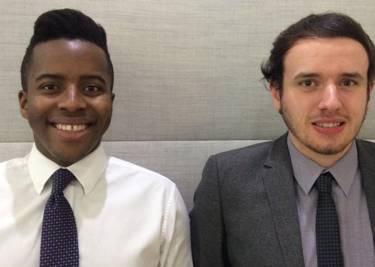 Deux stagiaires habillés formellement et souriants