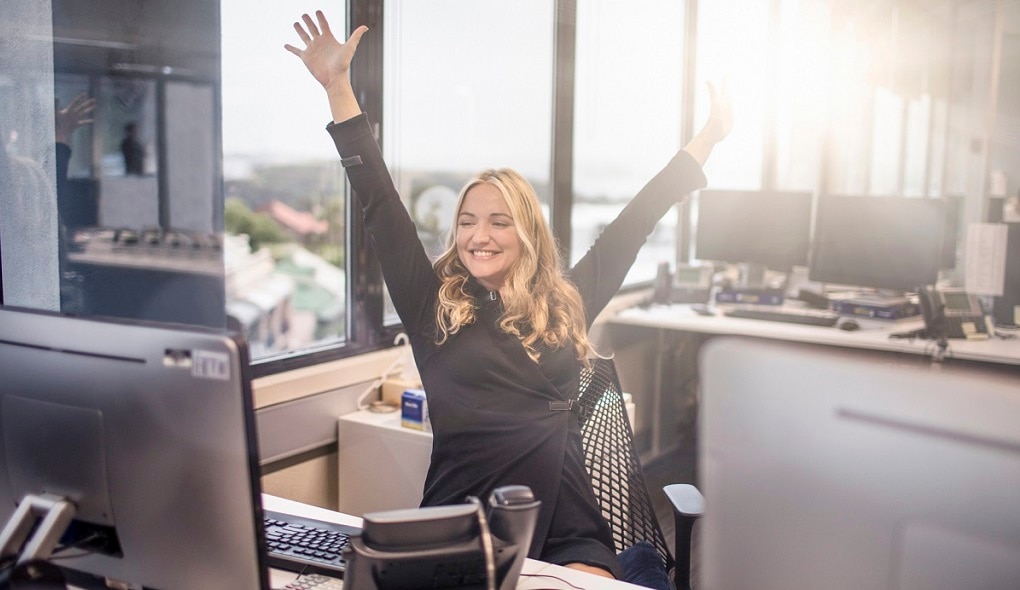 Ella levant les mains dans l'excitation à son bureau