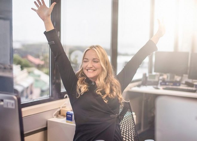 Ella levant les mains dans l'excitation à son bureau