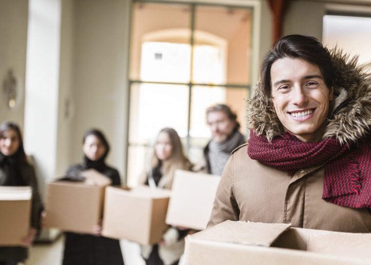 Personnes en manteau transportant des boîtes