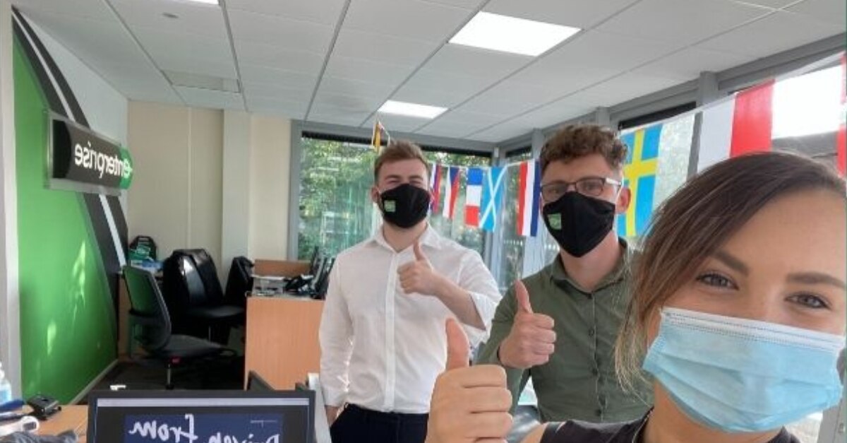 Employés d’Enterprise portant un masque au bureau pour un selfie