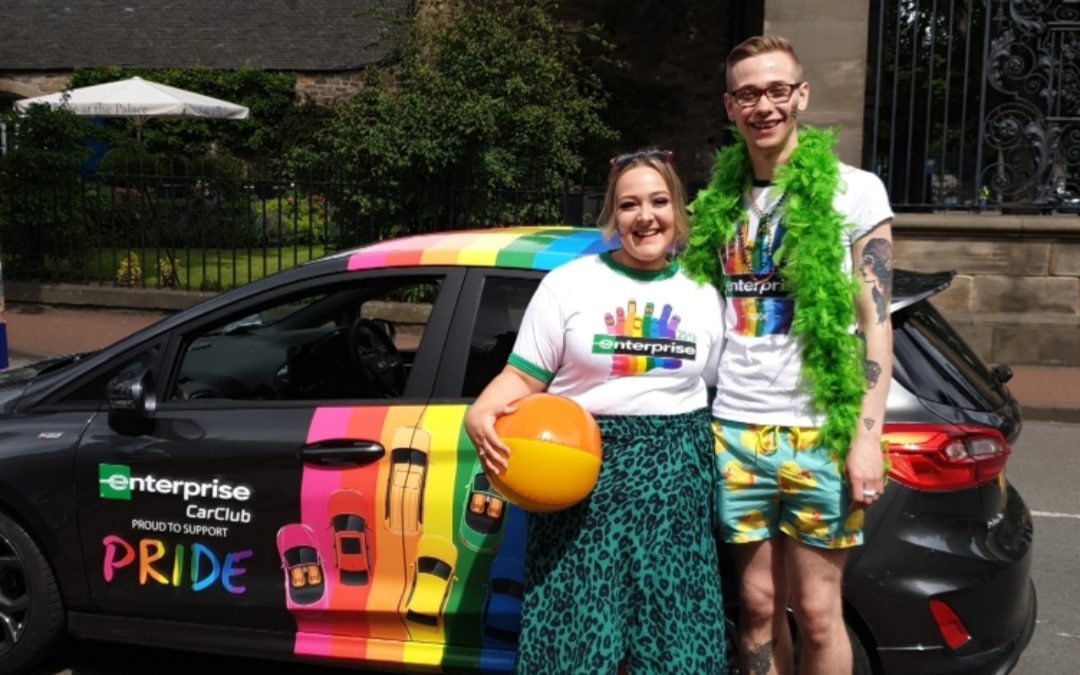 Dylan accompagné d’un autre employé d’Enterprise lors d’un événement PRIDE avec la voiture PRIDE D’Enterprise