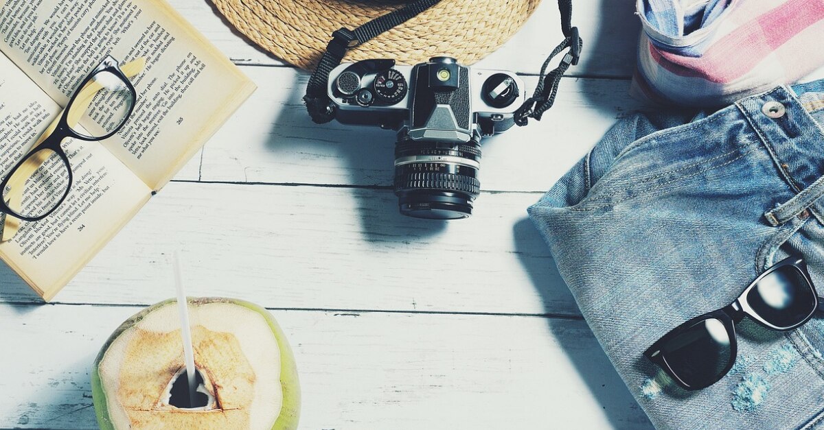 Appareil photo, noix de coco, livre, lunettes, lunettes de soleil, et des jeans