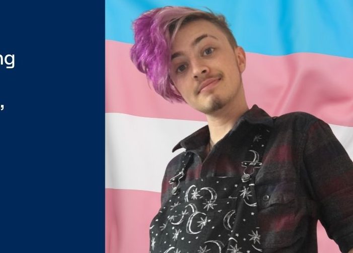 Photo de Jay devant un drapeau bleu, rose et blanc avec citation sur fond bleu
