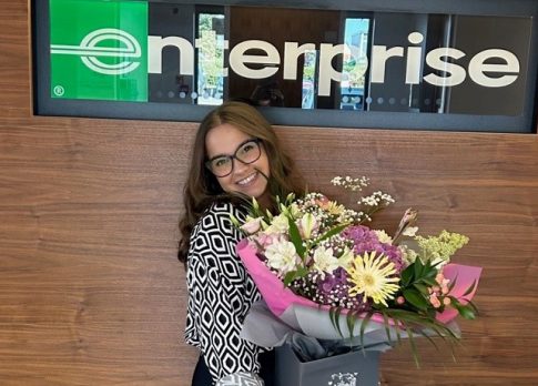 Photo de Yasmin avec des fleurs devant le panneau Enterprise avec devis