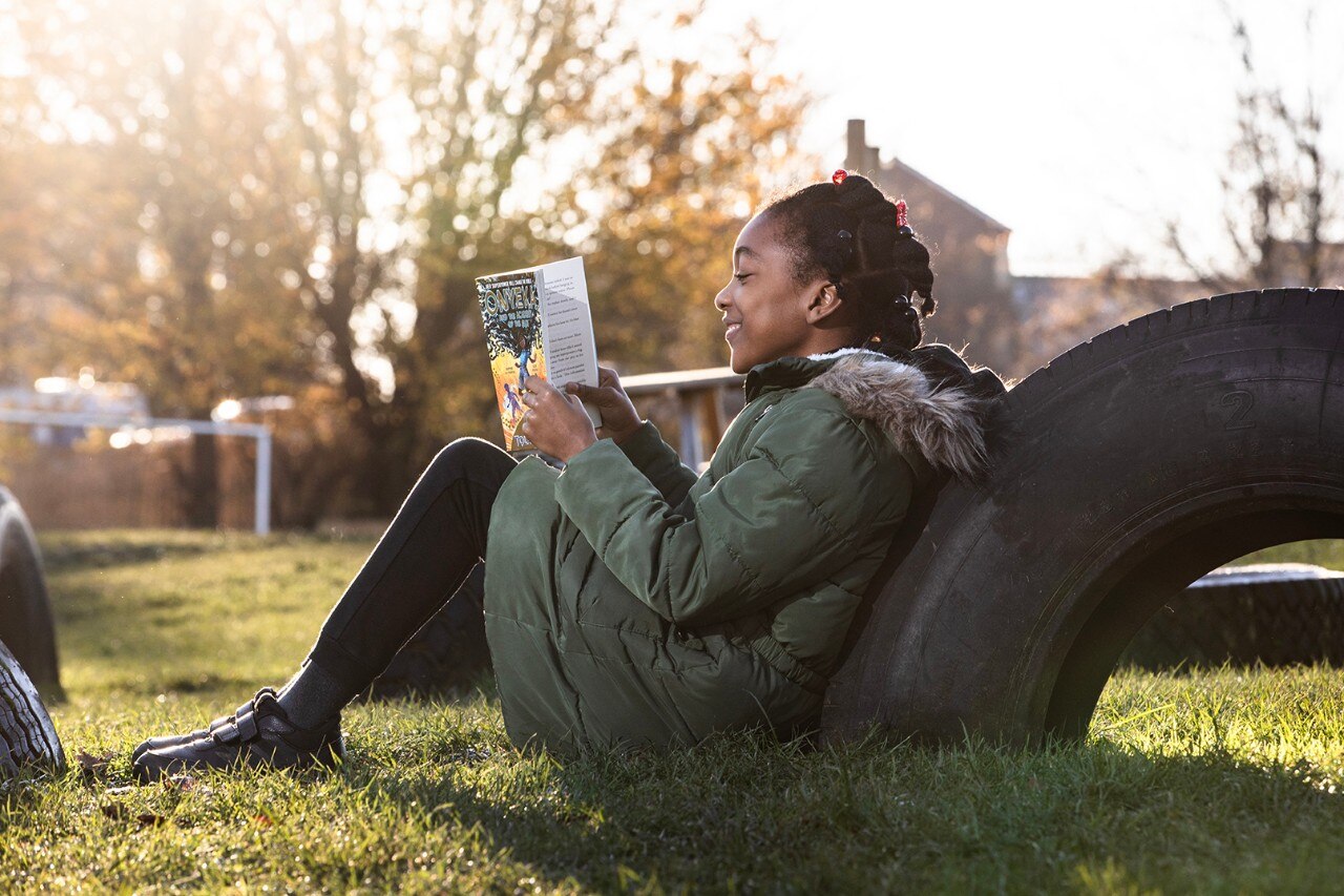 Un enfant lit un livre offert par le National Literacy Trust en collaboration avec Enterprise Mobility dans le cadre de l’initiative Road Forward. 