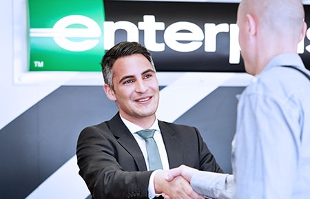 Enterprise Rent-A-Car employee shakes hand with customer