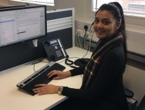 Vanessa travaille sur un ordinateur à un bureau avec un micro-casque